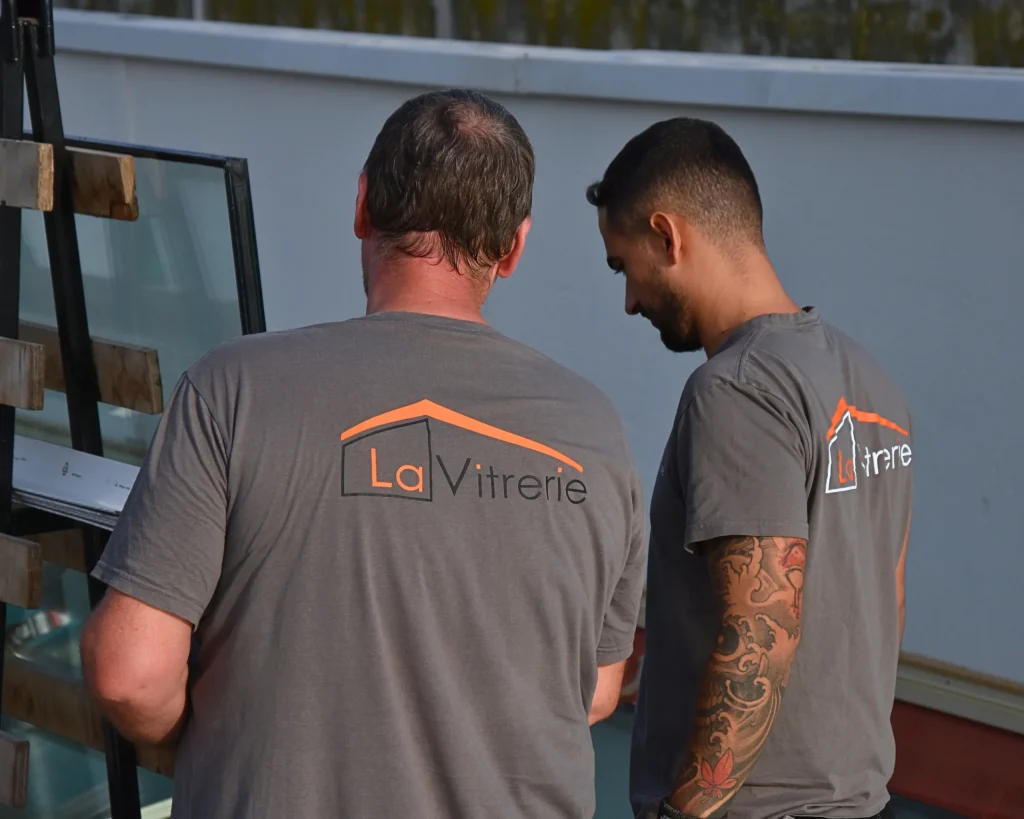 Deux techniciens de La Vitrerie, de dos sur le chantier en toiture du CFA BTP Perpignan